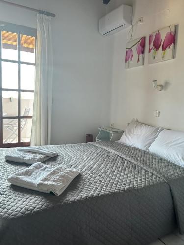 a bedroom with a bed with two towels on it at Villa Amy in Achladies