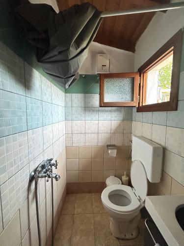 a bathroom with a toilet and a broken ceiling at Villa Amy in Achladies