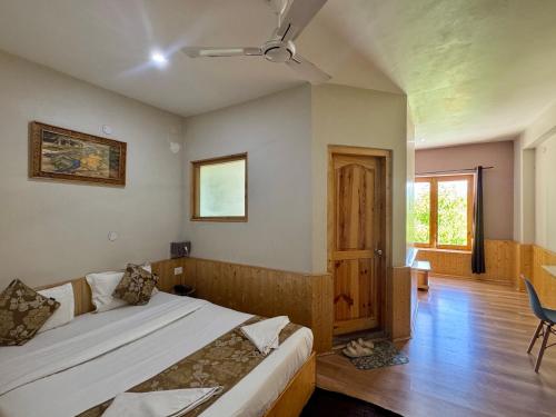 a bedroom with a bed with a ceiling fan at Adu's Eternal Comfort in Leh