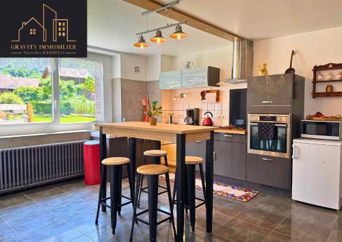 - une cuisine avec un comptoir et des tabourets dans l'établissement Maison tout confort avec jardin, à Bonneville