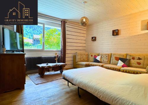 a bedroom with a bed and a tv and a couch at Maison tout confort avec jardin in Bonneville