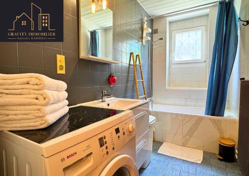 a bathroom with a washing machine and a sink at Maison tout confort avec jardin in Bonneville