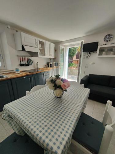 a kitchen with a table with a vase of flowers on it at Casa Pitturini in Marciana Marina