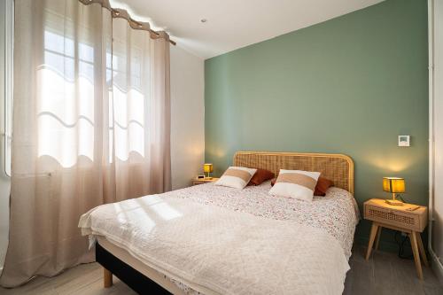 a bedroom with a bed with two lamps and a window at Maison à 1300 m des plages in Saint Malo