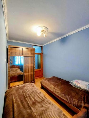 a bedroom with two beds and a mirror at Bina kutaisi zastava in Kutaisi