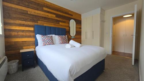 a bedroom with a large bed with a wooden wall at Charming Newly Renovated 2 Bed with free parking in Galway