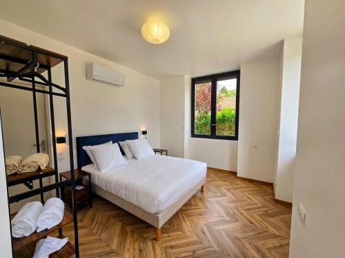a bedroom with a white bed and a window at L'appartement 1 by Vindihouses in Ressille