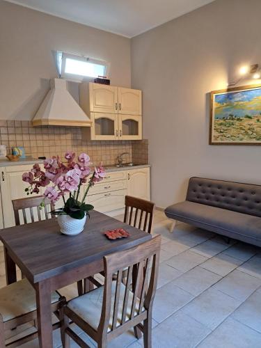a kitchen with a table with a vase of flowers on it at Corte Crudili in Presicce
