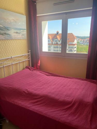 une chambre avec un lit et une grande fenêtre dans l'établissement Neptune I6 Hardelot, à Neufchâtel-Hardelot
