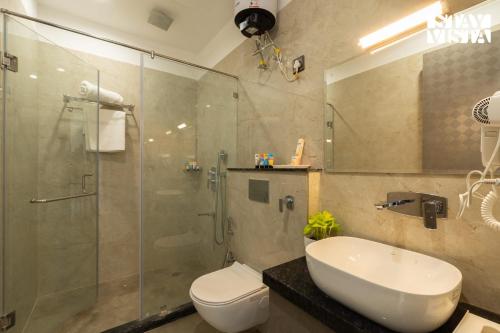 a bathroom with a shower and a toilet and a sink at StayVista at Eleganza Villas & Resort, Jaipur in Jaipur
