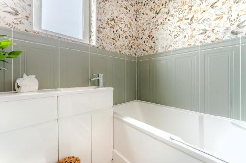 a bathroom with green walls and white cabinets at Charming 2 Bed Property in Upton