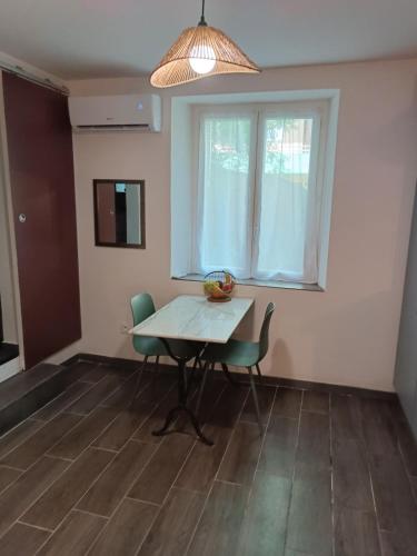 une salle à manger avec une table et des chaises et une fenêtre dans l'établissement Studio zen, à Bastia