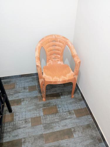 an orange chair sitting on a floor next to a wall at Aapka home in Neral