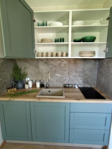 a kitchen with blue cabinets and a sink at Stara Karczma Sypitki in Sypitki