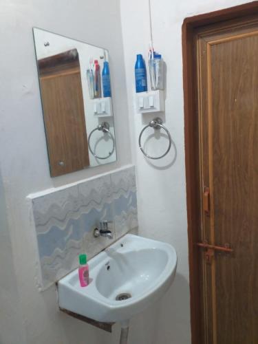 a bathroom with a white sink and a mirror at 2 BHK ENTIRE ROW HOUSE Home stay in nashik in Nashik