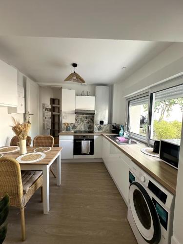 une cuisine avec une table et une salle à manger dans l'établissement Maisonnette Cosy T2 parking privé, à Niort