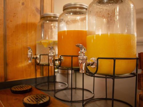 two glass jars filled with orange juice on a counter at Gasthaus & Hotel "Zum Boarn" in Rain