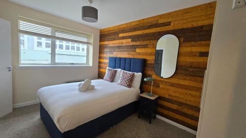 a bedroom with a bed with a wooden accent wall at Charming Newly Renovated 2 Bed with free parking in Galway