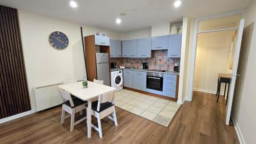 a kitchen with a table and a kitchen with blue cabinets at Charming Newly Renovated 2 Bed with free parking in Galway