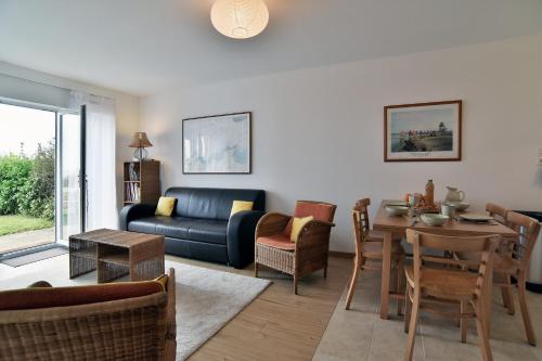 un salon avec une table et un canapé dans l'établissement Ar-Vro Côté Plage - Magnifique Vue Mer, à Saint-Cast-le-Guildo