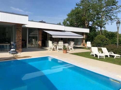 une piscine devant une maison dans l'établissement Les Acacias - Villa avec piscine, à Manneville-sur-Risle