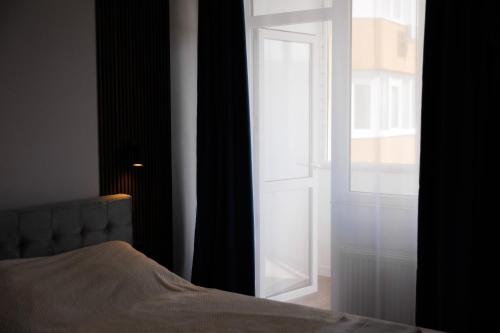 a bedroom with a bed and an open door at Apartment in Chișinău, near the Airport in Chişinău