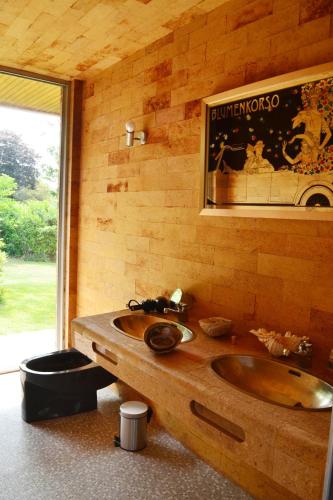 La salle de bains est pourvue d'un lavabo et d'un mur en bois. dans l'établissement Les Acacias - Villa avec piscine, à Manneville-sur-Risle