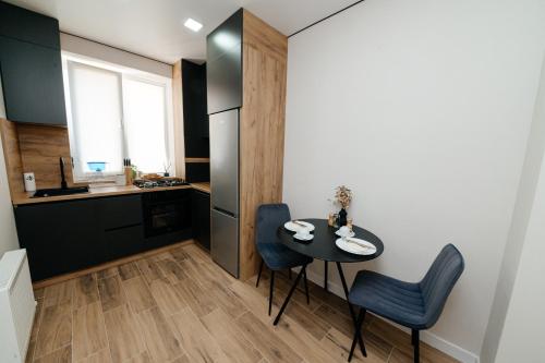 a small kitchen with a table and chairs in a room at Apartment in Chișinău, near the Airport in Chişinău