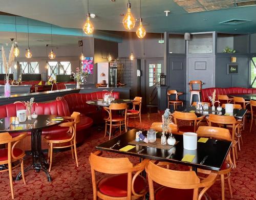 a restaurant with tables and chairs and a bar at Hotel Stadthafen Stade in Stade