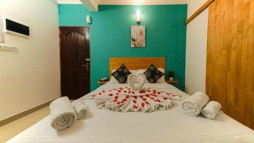 a bedroom with a bed with white towels on it at Vilu Rest in Hulhumale