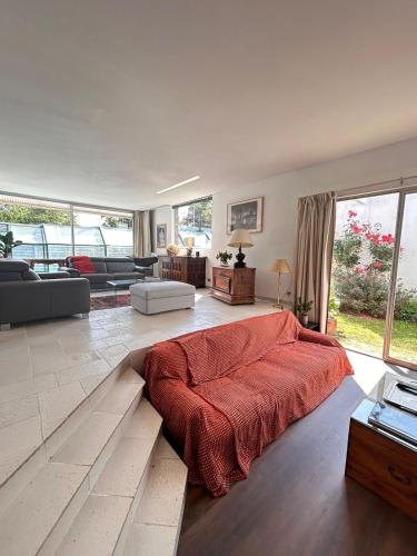 - un grand salon avec un grand lit rouge dans l'établissement Les Acacias - Villa avec piscine, à Manneville-sur-Risle