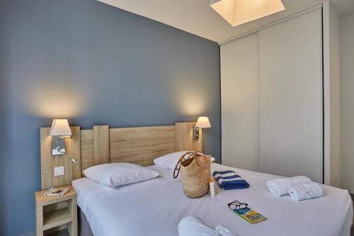 a bedroom with two beds with white pillows at Résidence Odalys Nakâra in Cap d'Agde