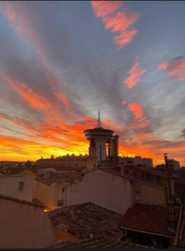 a building with a tower with a sunset in the background at Duplex Lumineux- Vue Canal- Centreville- 6pers in Palavas-les-Flots