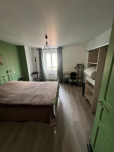 une chambre avec un lit, un bureau et une fenêtre dans l'établissement appart Alain, à Langogne