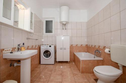 a bathroom with a toilet sink and a washing machine at Apartments Mrijana D in Barbat na Rabu