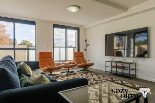 a living room with a couch and two chairs at KozyGuru | Homebush West | Modern 2R Apt + Parking in Sydney