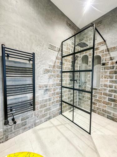 a glass shower in a room with a brick wall at La Finca - 3BR Seaside Villa with Private Pool & BBQ in Tangier