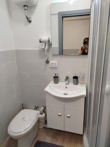 a person taking a picture of a bathroom with a toilet and sink at bed end breakfast scalea da romina in Scalea