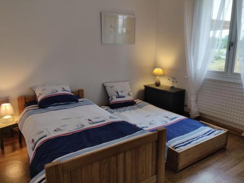 two twin beds in a bedroom with a window at Les Gaudouines in Saint-Mathurin
