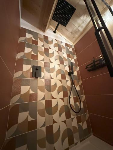 La salle de bains est pourvue d'une douche et d'un sol en damier. dans l'établissement Gîte de charme en Ardèche, à Saint-Étienne-de-Fontbellon