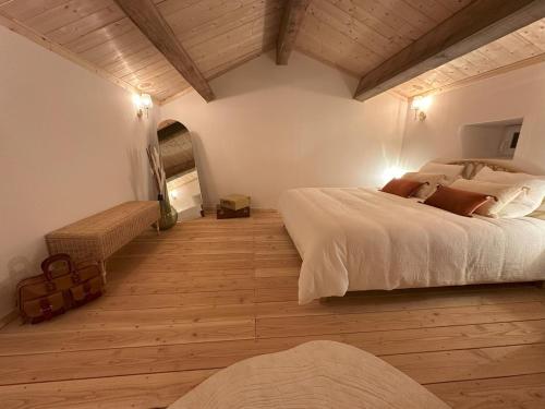 une chambre avec un grand lit et un parquet dans l'établissement Gîte de charme en Ardèche, à Saint-Étienne-de-Fontbellon