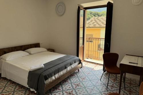 1 dormitorio con 1 cama y puerta a un balcón en Maripetra B&B, en Sangineto