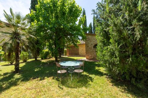 a table and chairs in a yard with trees at Tenuta Tegolato in Barberino di Val dʼElsa