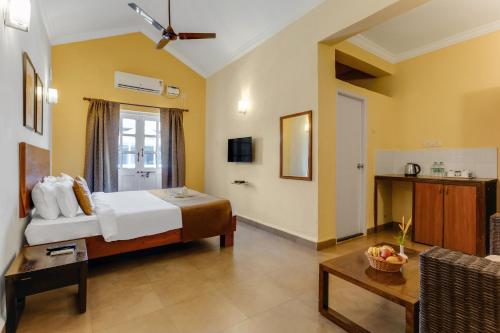 una camera da letto con un letto e un soggiorno di Aldeia Santa Rita - Candolim a Candolim