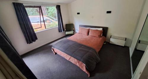 a bedroom with a large bed with a window at Okuti Retreat in Little River