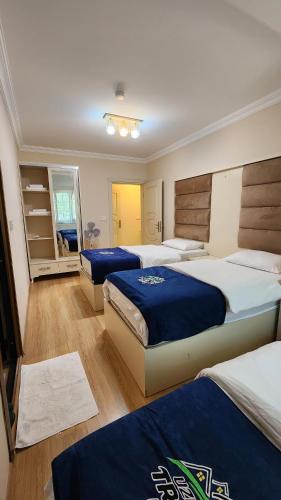 a bedroom with three beds with blue sheets at Trend Suite Hotel in Uzungöl