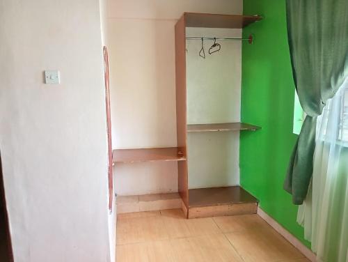 a room with green and white walls and wooden shelves at Malava-K-Resort in Kakamega