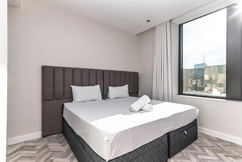 a bedroom with a large bed with a large window at Modern City Unit with Aircon, CoWorkspace, Secure Building in Cape Town