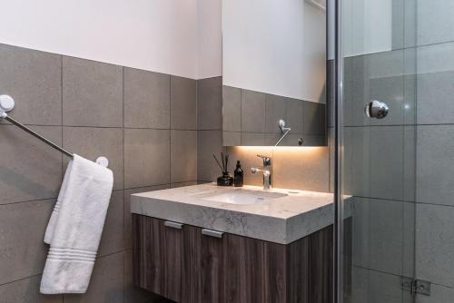 a bathroom with a sink and a shower at Modern City Unit with Aircon, CoWorkspace, Secure Building in Cape Town