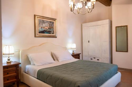 a bedroom with a bed and two lamps and a mirror at Tenuta Tegolato in Barberino di Val dʼElsa